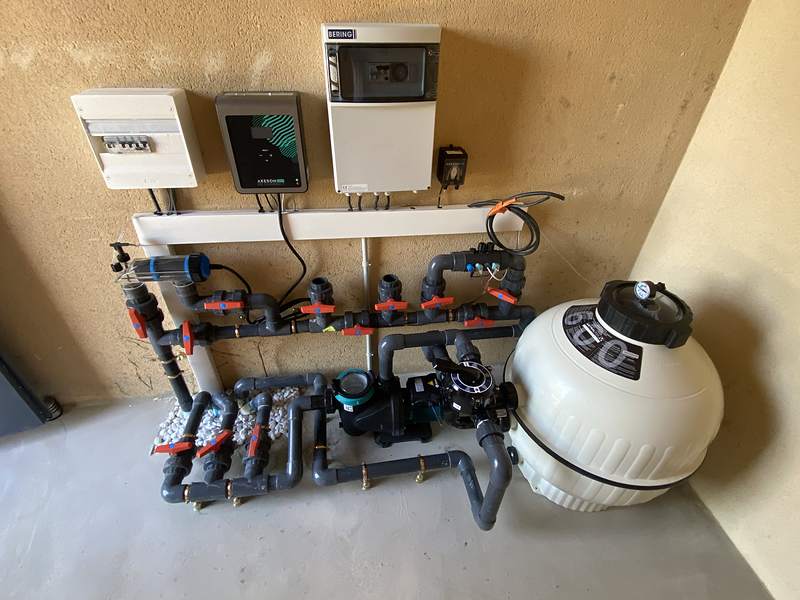Local technique de piscine : filtre à sable, pompe, vannes et coffrets de régulation