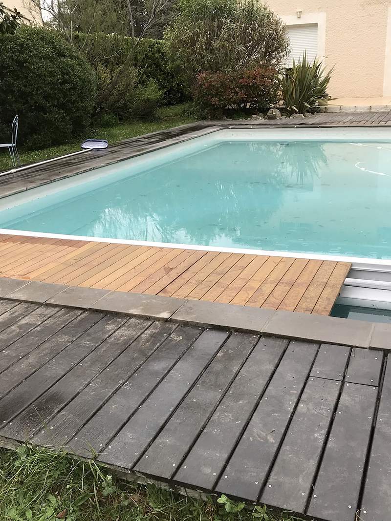 Volet roulant immergé sous caillebotis bois sur une piscine rénovée